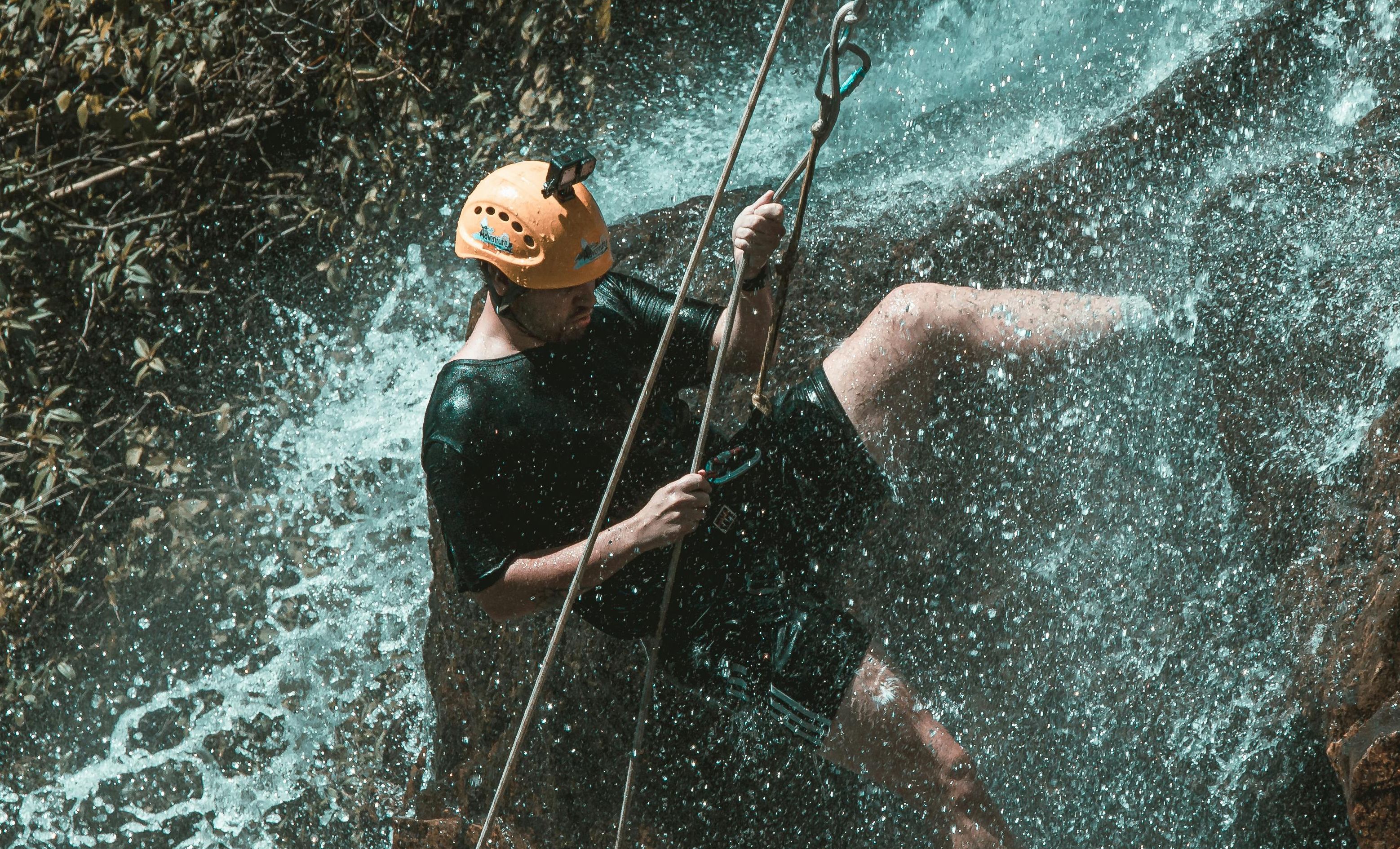 Homme Descendant en rapel dans une cascade